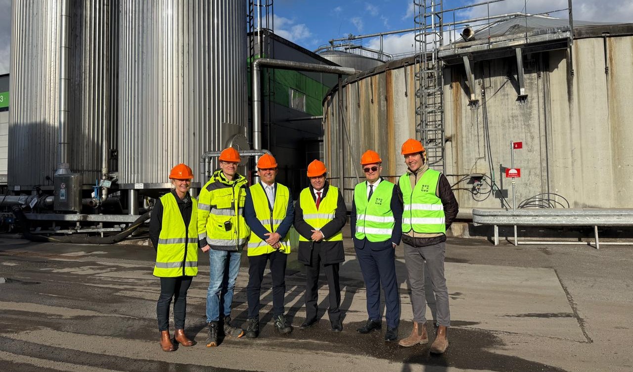 grupo de pessoas posa no pátio de uma fábrica